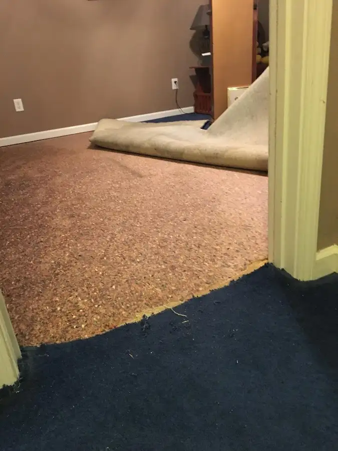 Carpet pad removal revealing water damage during Drying & Dehumidification in Surf City